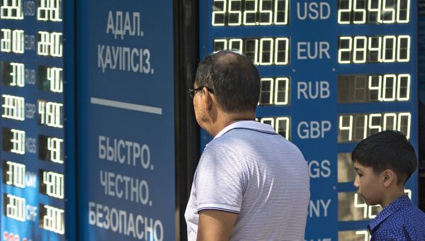 Мужчина у информационного табло обменного пункта валюты в Алма-Ате. 2015 год Мужчина у информационного табло обменного пункта валюты в Алма-Ате. 2015 год