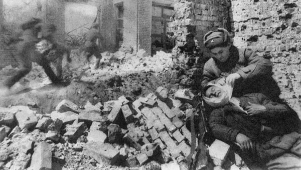 Сталинград. Декабрь 1942 г. Уличный бой. Санитарка перевязывает раненого Сталинград. Декабрь 1942 г. Уличный бой. Санитарка перевязывает раненого