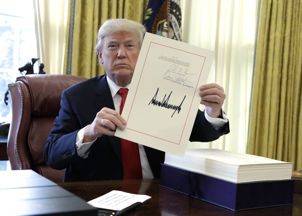 Президент США Дональд Трамп демонстрирует подписанный налоговый законопроект. 22 декабря 2017 Президент США Дональд Трамп демонстрирует подписанный налоговый законопроект. 22 декабря 2017