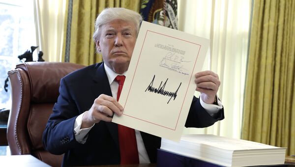 Президент США Дональд Трамп демонстрирует подписанный налоговый законопроект. 22 декабря 2017 Президент США Дональд Трамп демонстрирует подписанный налоговый законопроект. 22 декабря 2017