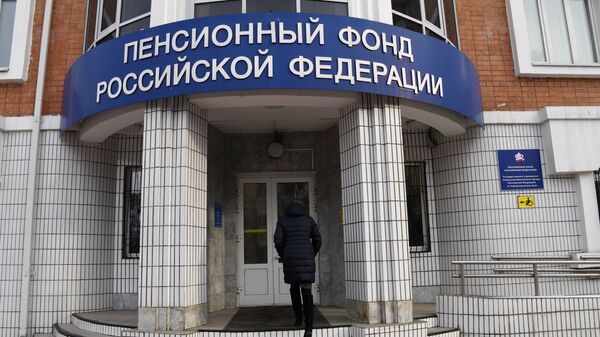 Женщина заходит в здание отделения Пенсионного фонда Российской Федерации Женщина заходит в здание отделения Пенсионного фонда Российской Федерации