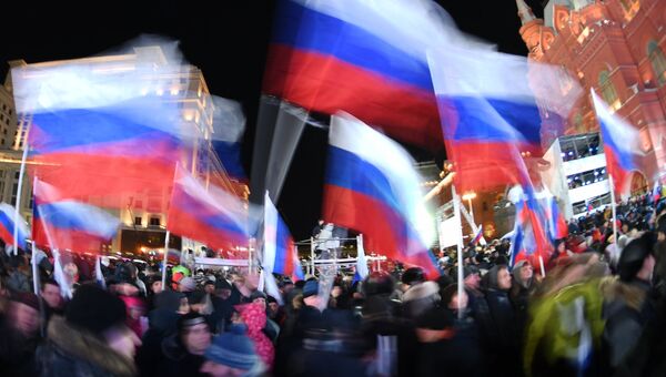 Люди с флагами России на Манежной площади. Архивное фото Люди с флагами России на Манежной площади. Архивное фото