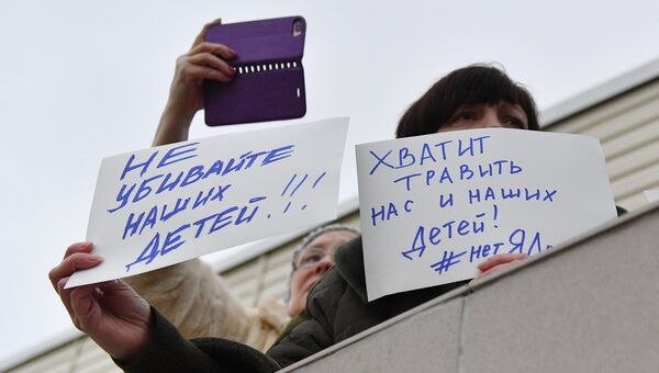 Люди с плакатами у Центральной районной больницы Волоколамска, куда жители обращались в связи с ухудшением самочувствия. 21 марта 2018 Люди с плакатами у Центральной районной больницы Волоколамска, куда жители обращались в связи с ухудшением самочувствия. 21 марта 2018