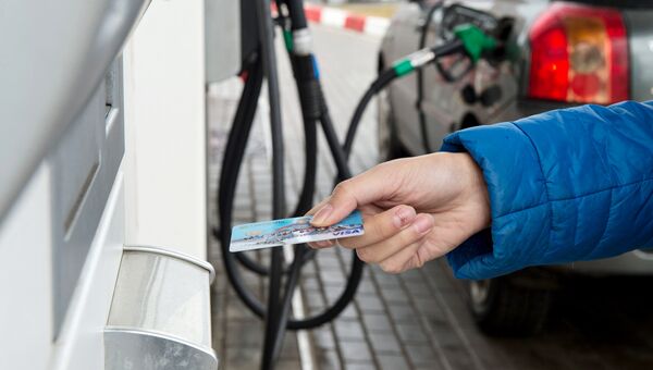 Женщина расплачивается кредитной картой на автозаправочной станции в Москве. Архивное фото Женщина расплачивается кредитной картой на автозаправочной станции в Москве. Архивное фото