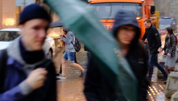 Пешеходы на улице в Москве во время сильного дождя. Архивное фото Пешеходы на улице в Москве во время сильного дождя. Архивное фото
