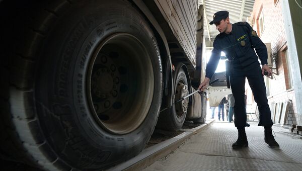 Сотрудник пограничной службы во время осмотра большегрузного автомобиля на многостороннем автомобильном пункте пропуска Пограничный в Приморском крае на российско-китайской границе Сотрудник пограничной службы во время осмотра большегрузного автомобиля на многостороннем автомобильном пункте пропуска Пограничный в Приморском крае на российско-китайской границе