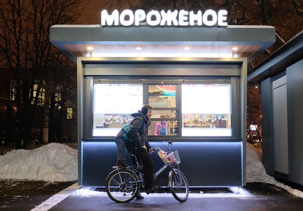 Велосипедист у киоска продажи мороженого на улице Москвы Велосипедист у киоска продажи мороженого на улице Москвы