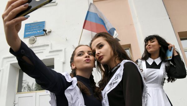 Выпускницы делают селфи у входа в школу №47 во время празднования последнего звонка в городе Чите Выпускницы делают селфи у входа в школу №47 во время празднования последнего звонка в городе Чите