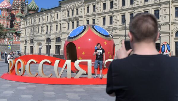 Молодые люди фотографируются рядом с символикой, посвященной предстоящему чемпионату мира по футболу 2018 в Москве. Архивное фото Молодые люди фотографируются рядом с символикой, посвященной предстоящему чемпионату мира по футболу 2018 в Москве. Архивное фото