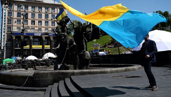 Молодой человек с украинским флагом у памятника основателям Киева на площади Независимости. Архивное фото Молодой человек с украинским флагом у памятника основателям Киева на площади Независимости. Архивное фото