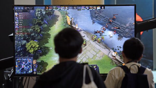Подростки следят за игрой команд в Dota 2 на чемпионате в Сиэтле Подростки следят за игрой команд в Dota 2 на чемпионате в Сиэтле
