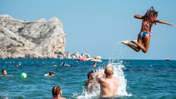 Отдыхающие купаются в Черном море в Судаке Отдыхающие купаются в Черном море в Судаке
