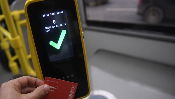 Пассажир прикладывает билет к валидатору в автобусе в Москве. Архивное фото Пассажир прикладывает билет к валидатору в автобусе в Москве. Архивное фото