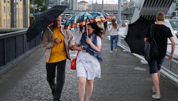 Прохожие на Крымском мосту во время дождя в Москве. Архивное фото Прохожие на Крымском мосту во время дождя в Москве. Архивное фото
