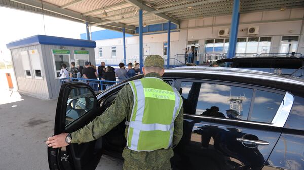 Сотрудник пограничной службы во время осмотра автомобиля на пограничном контрольно-пропускном пункте Бугристое российско-казахстанской границы Сотрудник пограничной службы во время осмотра автомобиля на пограничном контрольно-пропускном пункте Бугристое российско-казахстанской границы