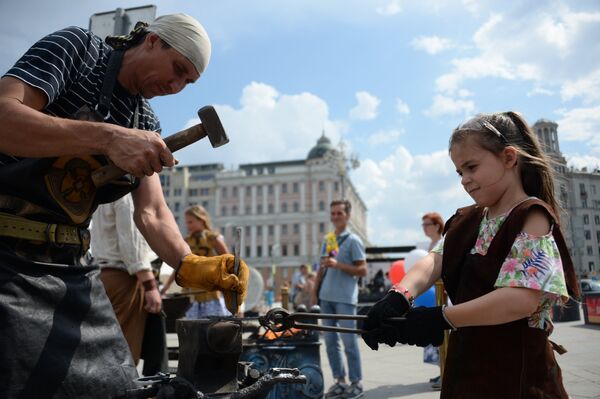 Посетители во время мастер-класса по кузнечному делу на фестивале Многонациональная Россия в Москве Посетители во время мастер-класса по кузнечному делу на фестивале Многонациональная Россия в Москве