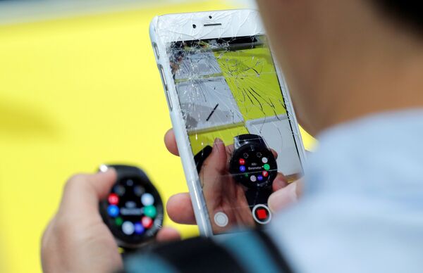 Посетитель фотографирует на iPhone часы Samsung Galaxy Watch на презентации Galaxy Unpacked в Нью-Йорке Посетитель фотографирует на iPhone часы Samsung Galaxy Watch на презентации Galaxy Unpacked в Нью-Йорке