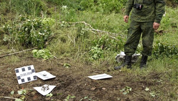Военнослужащий ЛНР на месте попадания снаряда, выпущенного артиллерией ВСУ по поселку Калиново Луганской области. 20 мая 2018 Военнослужащий ЛНР на месте попадания снаряда, выпущенного артиллерией ВСУ по поселку Калиново Луганской области. 20 мая 2018