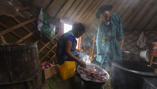 Монгольская женщина готовит еду в юрте Монгольская женщина готовит еду в юрте
