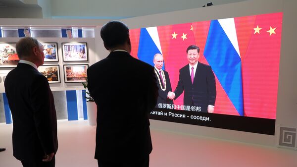 Президент РФ Владимир Путин и председатель Китайской Народной Республики Си Цзиньпин во время осмотра выставки в рамках IV Восточного экономического форума