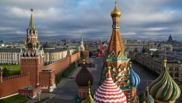 На первом плане купола Храма Василия Блаженного на Красной площади в Москве. Архивное фото На первом плане купола Храма Василия Блаженного на Красной площади в Москве. Архивное фото