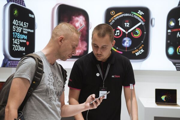 Мужчина рассматривает телефон iPhone XS Max в магазине re:Store торгово-развлекательного центра «Галерея» в Санкт-Петербурге Мужчина рассматривает телефон iPhone XS Max в магазине re:Store торгово-развлекательного центра «Галерея» в Санкт-Петербурге