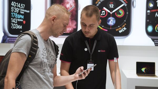 Мужчина рассматривает телефон iPhone XS Max в магазине re:Store торгово-развлекательного центра «Галерея» в Санкт-Петербурге Мужчина рассматривает телефон iPhone XS Max в магазине re:Store торгово-развлекательного центра «Галерея» в Санкт-Петербурге