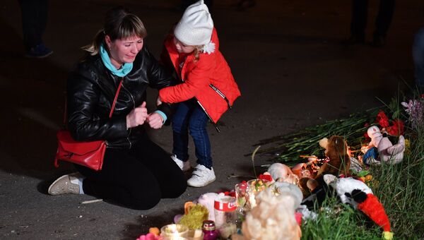 Женщина у народного мемориала на улице в Керчи, где в Керченском политехническом колледже произошли взрыв и стрельба Женщина у народного мемориала на улице в Керчи, где в Керченском политехническом колледже произошли взрыв и стрельба