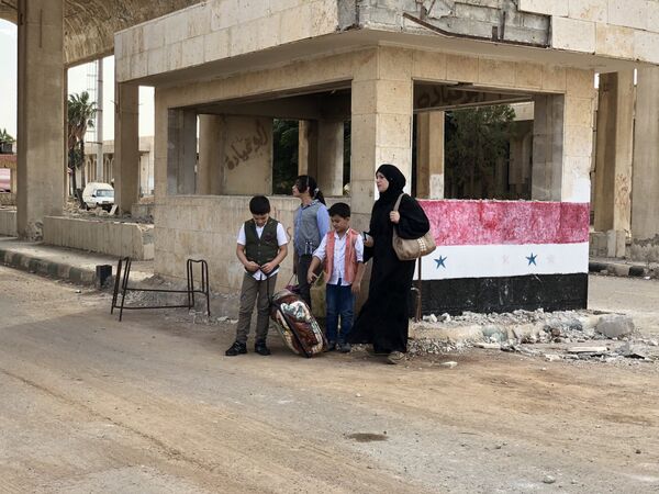 Женщина с детьми в современной части города Босра сирийской провинции Дераа в районе пограничного перехода Насиб на границе с Иорданией Женщина с детьми в современной части города Босра сирийской провинции Дераа в районе пограничного перехода Насиб на границе с Иорданией