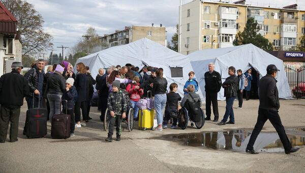 Пассажиры у полевого лагеря, развернутого добровольцами для организации питания пассажиров поездов, задержанных в Краснодарском крае из-за наводнения Пассажиры у полевого лагеря, развернутого добровольцами для организации питания пассажиров поездов, задержанных в Краснодарском крае из-за наводнения