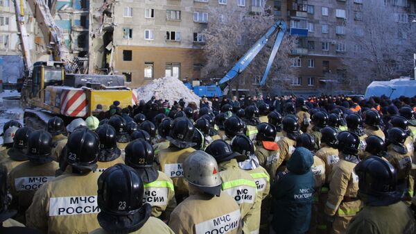 Сотрудники МЧС РФ во время минуты молчания по погибшим после обрушения одного из подъездов жилого дома в Магнитогорске. 4 января 2019 Сотрудники МЧС РФ во время минуты молчания по погибшим после обрушения одного из подъездов жилого дома в Магнитогорске. 4 января 2019