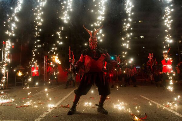 Участник фестиваля Correfoc в костюме демона в Пальма-де-Мальорке, Испания Участник фестиваля Correfoc в костюме демона в Пальма-де-Мальорке, Испания