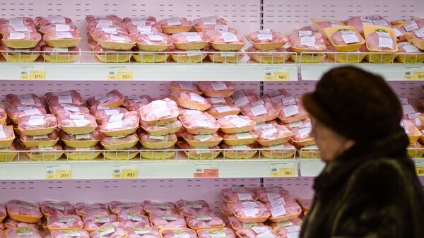 Посетитель у стеллажа с мясом птицы Посетитель у стеллажа с мясом птицы