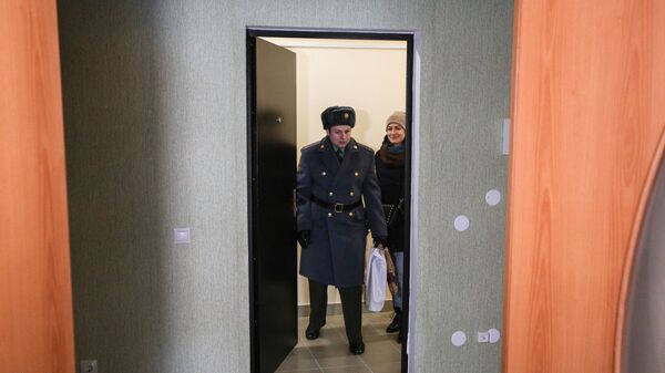 Новоселы заходят в свою новую квартиру после церемонии торжественной передачи служебного жилья военнослужащим войсковой части