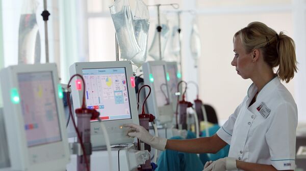 Медсестра контролирует работу аппарата Искусственная почка Медсестра контролирует работу аппарата Искусственная почка