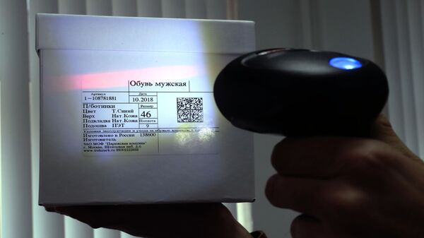 Сканер штрих-кода считывает этикетку с QR-кодом с коробки с обувью Сканер штрих-кода считывает этикетку с QR-кодом с коробки с обувью