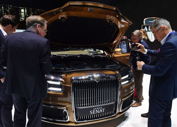 Посетители осматривают моторный отсек автомобиля Aurus Senat S600 на Международном Женевском автосалоне 2019 Посетители осматривают моторный отсек автомобиля Aurus Senat S600 на Международном Женевском автосалоне 2019
