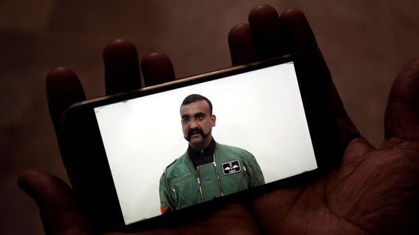Мужчина смотрит новости о сбитом над Кашмиром пилотом ВВС Индии Абхинандане Вартхамане на экране смартфона