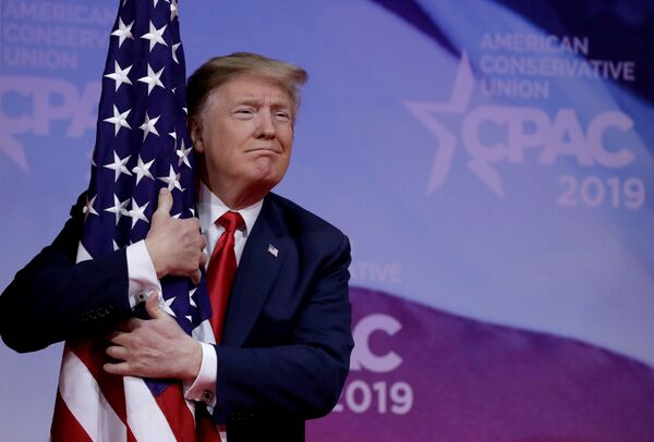 Президент США Дональд Трамп обнимает американский флаг Президент США Дональд Трамп обнимает американский флаг