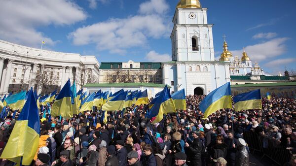 Люди слушают предвыборную речь президента Украины Петра Порошенко на Михайловской площади в Киеве