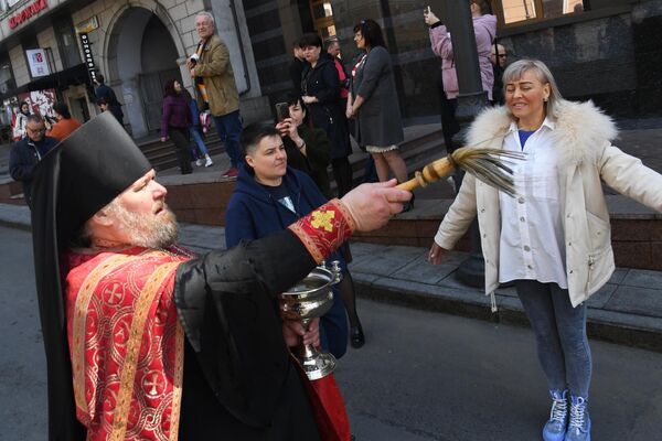 Священник освящает людей во время пасхального крестного хода во Владивостоке Священник освящает людей во время пасхального крестного хода во Владивостоке