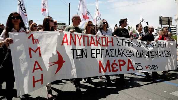 Участники первомайской демонстрации в Афинах, протестующие против экономической политики правительства и выступающие за реализацию прав трудящихся на достойную зарплату и социальную защиту Участники первомайской демонстрации в Афинах, протестующие против экономической политики правительства и выступающие за реализацию прав трудящихся на достойную зарплату и социальную защиту