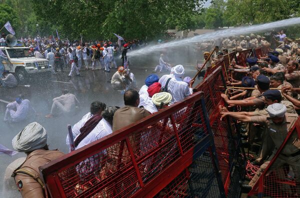 Полиция поливает водой демонстрантов во время акции протеста в индийском Чандигархе Полиция поливает водой демонстрантов во время акции протеста в индийском Чандигархе
