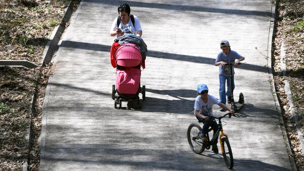 Женщина гуляет с детьми в парке