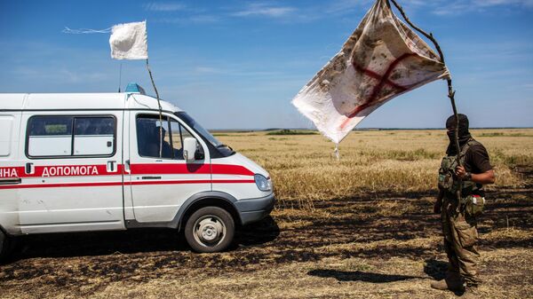 Украинский военный с белым флагом во время передачи убитых на нейтральной территории вблизи поселка Диброво возле российско-украинской границы в Донецкой области Украинский военный с белым флагом во время передачи убитых на нейтральной территории вблизи поселка Диброво возле российско-украинской границы в Донецкой области