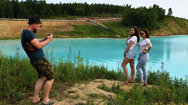 Молодые люди фотографируются на фоне золоотвала Новосибирской ТЭЦ-5