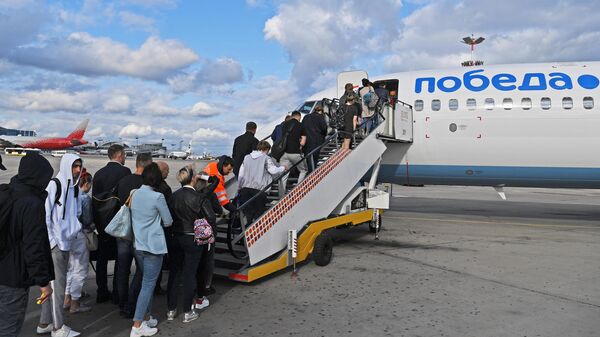 Пассажиры проходят на посадку в самолет авиакомпании Победа в аэропорту Внуково Пассажиры проходят на посадку в самолет авиакомпании Победа в аэропорту Внуково