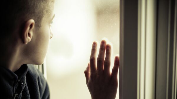 Подросток смотрит в окно 