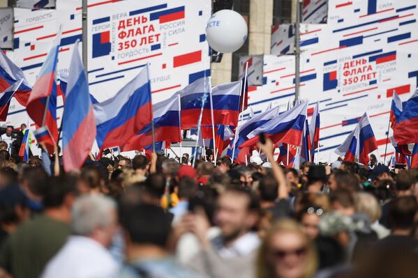 Участники флешмоба в честь Дня государственного флага России на проспекте Сахарова в Москве Участники флешмоба в честь Дня государственного флага России на проспекте Сахарова в Москве