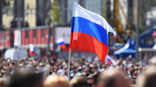 Участники флешмоба в честь Дня государственного флага России на проспекте Сахарова в Москве Участники флешмоба в честь Дня государственного флага России на проспекте Сахарова в Москве